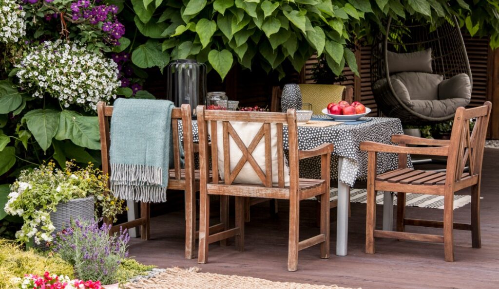 A table with four chairs and a bowl of fruit.